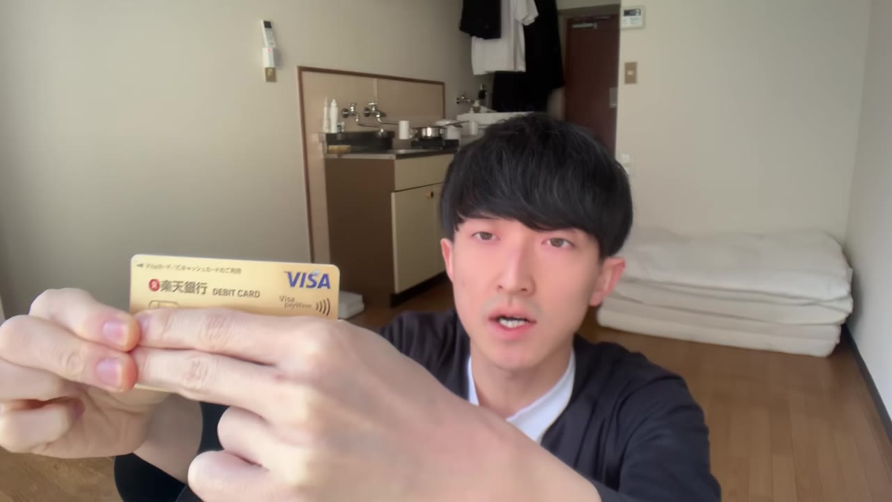デビットカードを手に持って説明