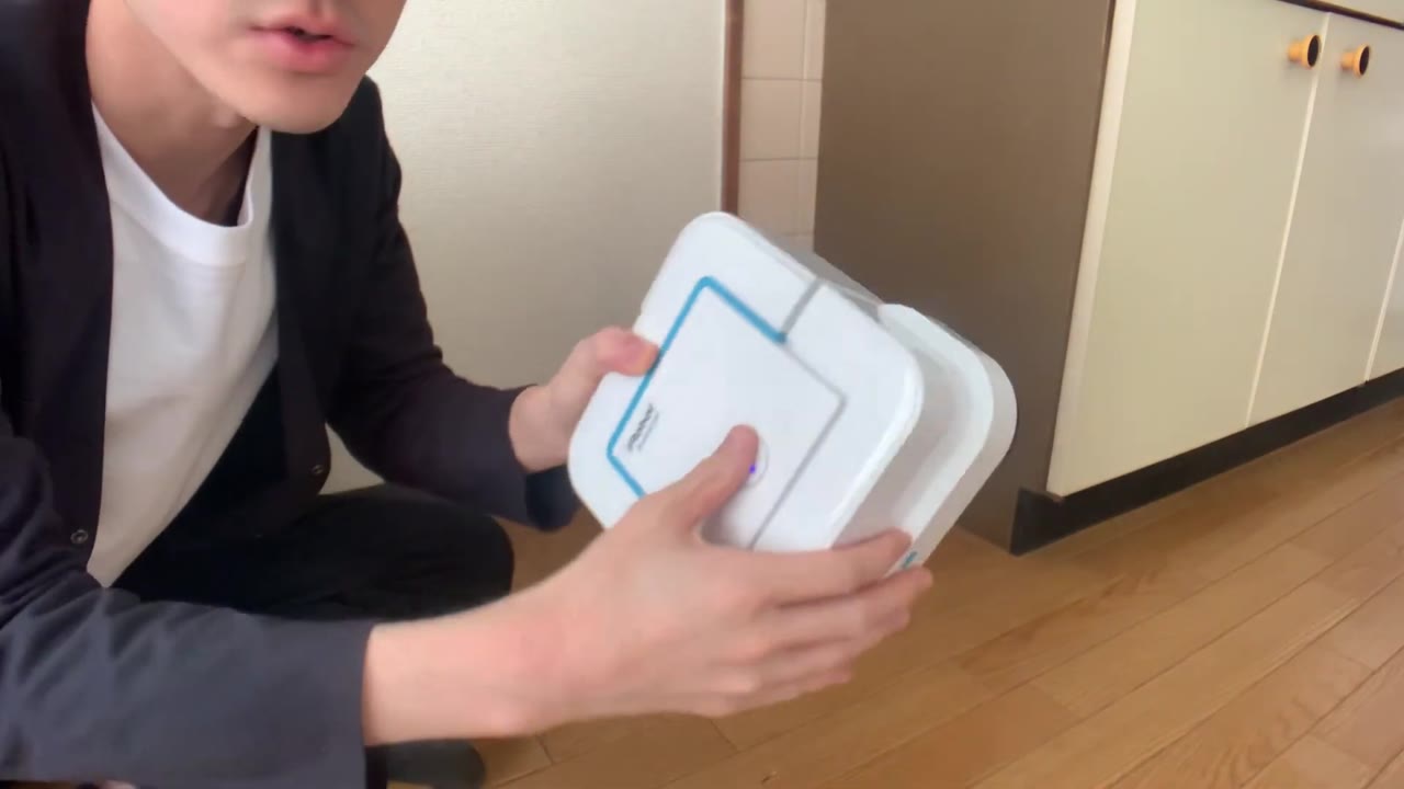 お掃除ロボット「ブラーバ」を手に持つ