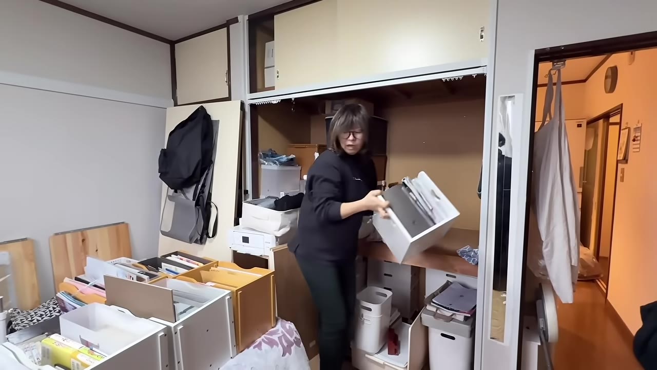 押し入れの前で、家中から集めた本や書類を仕分けていく
